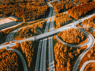 Aerial view of highway and overpass with autumn color woods on a fall day in Finland.