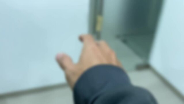 First person point of view walking in office room feeling dizzy white wall interior blurry motion right hand try to reach for glass door handle and falling on the ground floor and become unconscious