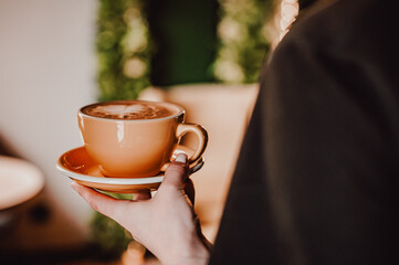 Woman hands holding cup of hot coffee latte cappuccino