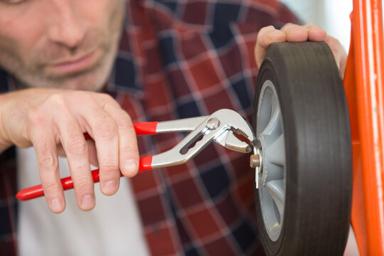 man using pliers to place a split pin