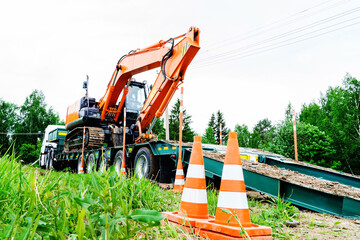 Loading or unloading heavy construction equipment. Transporting an excavator to a construction site...