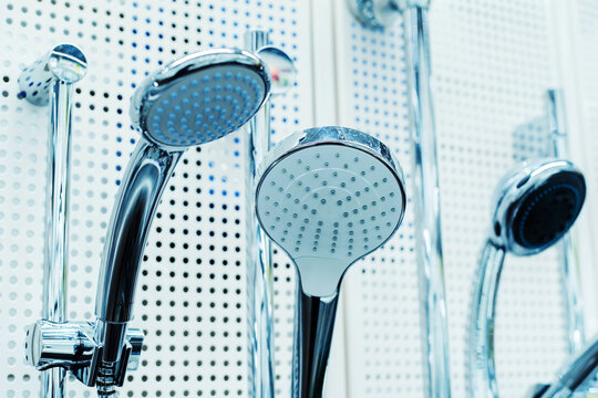 Plumbing fixtures for showers of different shapes and sizes on a store display. Foreground. Selective focus
