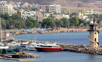 Fototapeta na wymiar The beach of the city of Aqaba, located in the Gulf of Aqaba on the Red Sea