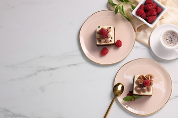 Pieces of triple chocolate mousse cake with raspberries served on white marble table, flat lay....