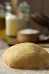 Fototapeta na wymiar Raw dough and flour on table, closeup