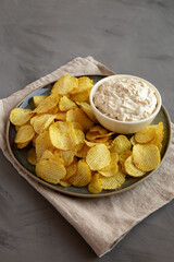 Crispy Crinkle Potato Chips and French Onion Dip on a Plate, side view.