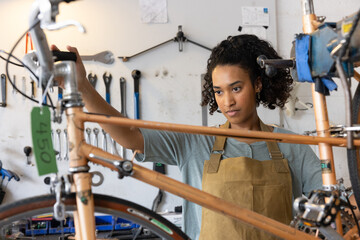 Young adult female repairing a bicycle in a bike store
