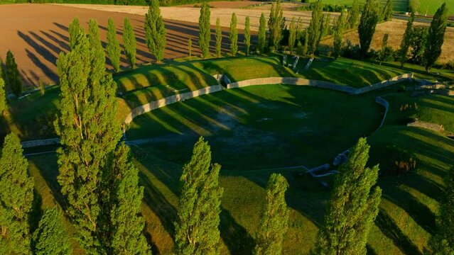 Ruins Of The Ancient Amphitheater Of Carnuntum In Austria At Sunset - aerial drone shot