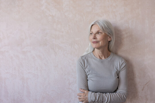 Senior woman looking ahead to the future with a neutral background