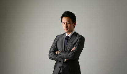 Obraz na płótnie Canvas 腕組をするスーツを着た日本人ビジネスマン
