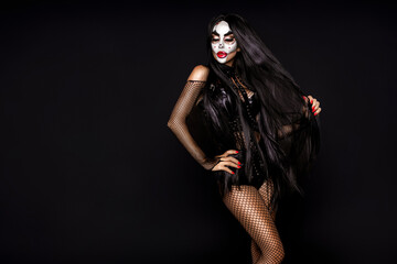 Sexy woman in a Halloween makeup and costume on black background. Halloween makeup and costume...