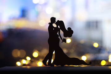 Black silhouettes of pair dancers performing. Man and woman are dancing on gray background with...
