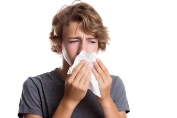 Sick teenage boy sneezes into a paper napkin or handkarchief on white background. New outbreak of the coronavirus pandemic. Covid pandemic in 2024 2025 pirola strain and omicron disease concept