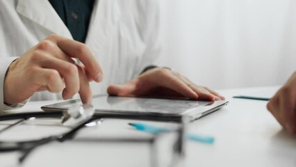 Analysis. A young specialist in a white coat uses a modern tablet to enter data in a doctor's waiting room. Doctor uses technology, modern touch tablet, applies proven examination methods medical care - Powered by Adobe