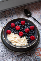 Oatmeal for breakfast with raspberries and blueberries
