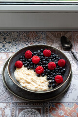 Oatmeal for breakfast with raspberries and blueberries