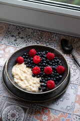 Oatmeal for breakfast with raspberries and blueberries