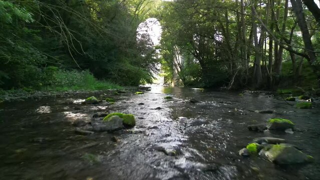 Babbling Brook drone low fly over in slo-mo - Chirk Aqueduct background, River Ceiriog, Chirk, Wales UK - hazy summer afternoon - Sept 23