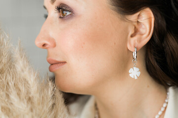 Detail of young woman wearing beautiful luxury earring. Handmade jewellery and accessories