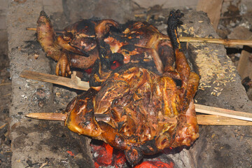 Photo of traditional Indonesian food, a rooster being grilled with billowing smoke