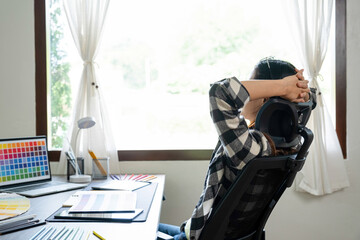 Young female architect envisions project at office desk.
