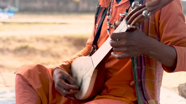 A close-up shot captures the soulful melodies of folk music being passionately played in an Indian village, celebrating cultural richness.