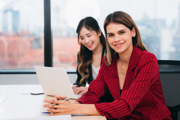 Obraz premium Portrait of business leader looking at camera in working space. Diverse Young Professionals in a Modern Office: Collaboration and Innovation.