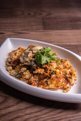 local traditional chinese stir wok fried big fresh oyster seafood with crispy chicken egg omelette in plate on wood table asian restaurant banquet cuisine halal food menu