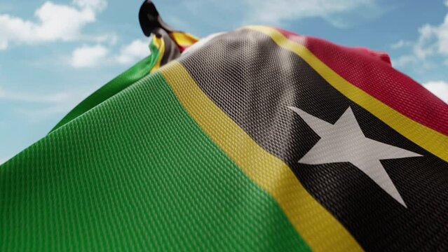 Wavy flag of Saint Kitts and Nevis blowing in the wind in slow motion. Waving official flag team symbol abstract vertical background. Blue sky with clouds. World countries flying flags concept