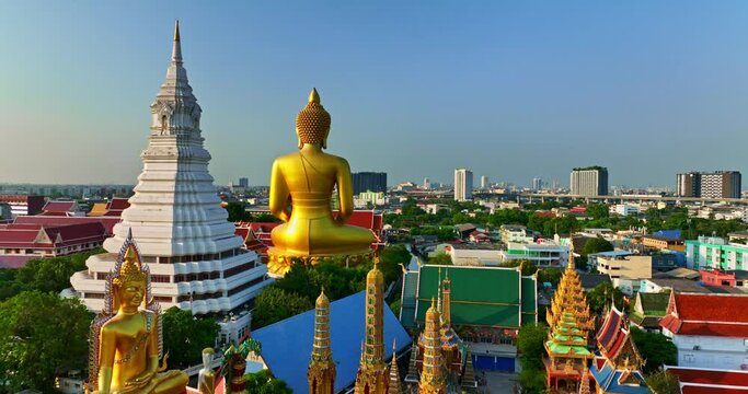 aerial view on the back of golden big Buddha Wat Paknam Phasi Charoen and pagodas..Small canal beside the Big Buddha It is a passenger route for people in the area..Dense buildings in the community.