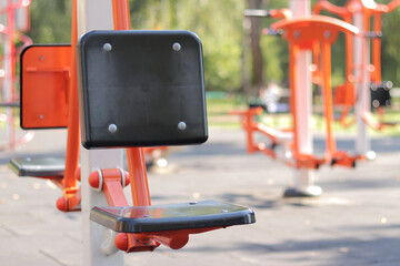 Outdoor sports equipment, sports ground. Outdoor training. Sports concept, selective focus. Exercise machine seat. Summer