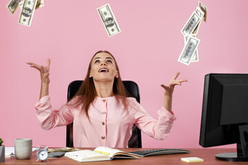 pretty businesswoman throwing money on pink background.