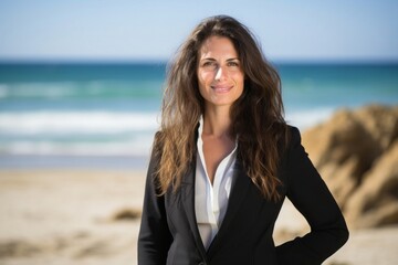 Fototapeta na wymiar portrait of a confident Israeli woman in her 30s wearing a classic blazer against a beach background
