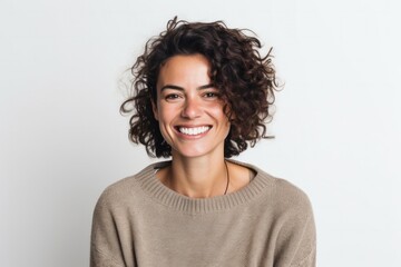 portrait of a confident Israeli woman in her 30s wearing a cozy sweater against a white background