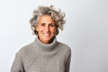portrait of a confident Israeli woman in her 50s wearing a cozy sweater against a white background