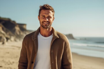 portrait of a confident Polish man in his 20s wearing a chic cardigan against a beach background