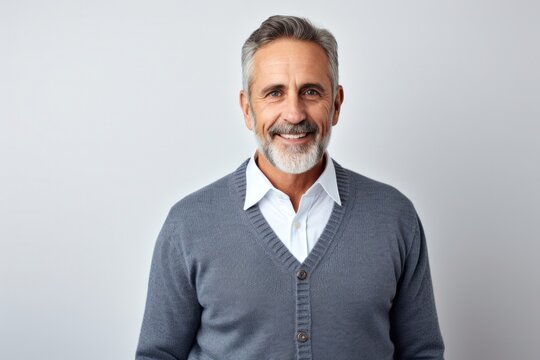 Portrait of a Israeli man in his 50s wearing a chic cardigan against a white background