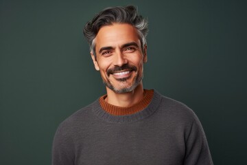 Fototapeta premium medium shot portrait of a confident Mexican man in his 40s wearing a cozy sweater against an abstract background