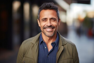 Fototapeta premium medium shot portrait of a confident Mexican man in his 40s wearing a chic cardigan against an abstract background