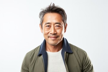 Portrait of a confident Japanese man in his 40s wearing a chic cardigan against a white background