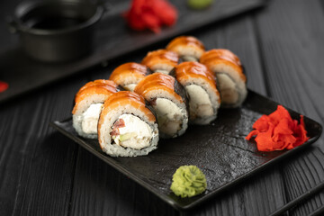Sushi roll with salmon, avocado and cream cheese on black background. Sushi menu. Japanese food concept.