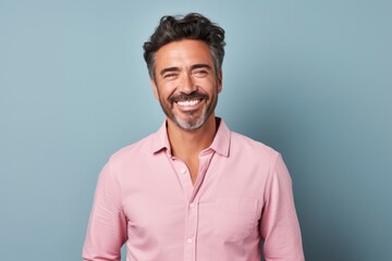 Fototapeta premium Portrait of a confident Mexican man in his 40s wearing a chic cardigan against a pastel or soft colors background