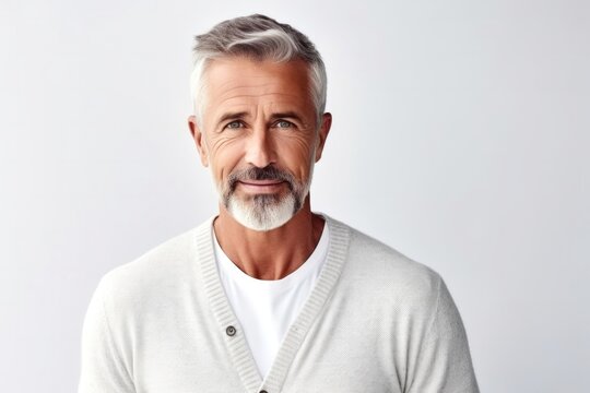 medium shot portrait of a confident Polish man in his 50s wearing a chic cardigan against a white background