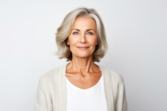 medium shot portrait of a confident Polish woman in her 50s wearing a chic cardigan against a white background