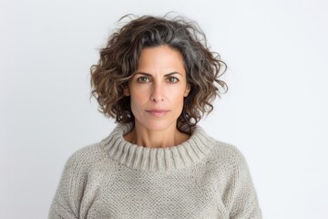 medium shot portrait of a serious, Israeli woman in her 40s wearing a cozy sweater against a white background