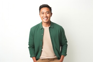 medium shot portrait of a happy Filipino man in his 30s wearing a chic cardigan against a white background