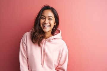 medium shot portrait of a happy Filipino woman in her 20s wearing a stylish hoodie against an abstract background - Powered by Adobe