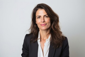 medium shot portrait of a Israeli woman in her 40s wearing a classic blazer against a white background