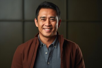 portrait of a happy Filipino man in his 40s wearing a chic cardigan against an abstract background - obrazy, fototapety, plakaty