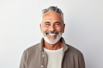 portrait of a happy Israeli man in his 50s wearing a chic cardigan against a minimalist or empty room background